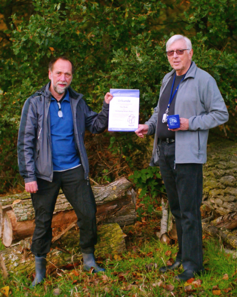Karl Wehr (links) übergibt Hans Bender die Urkunde und DGfM-Tasse anlässlich des Wolfgang-Beyer-Preis 2019